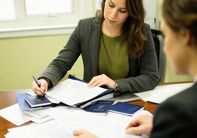 Passport document specialist reviewing travel papers at a desk in a Damascus, Maryland office